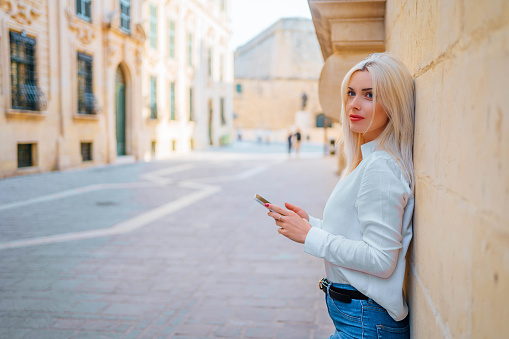 Young woman with smartphone using phone in Valletta, Malta