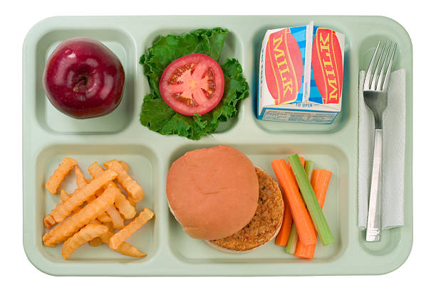 School Food - Veggie Burger "A straight shot of a tray of a typical school lunch tray consisting of a vegetarian burger, fries,  carrot and celery sticks, an apple, lettuce and tomato with cold milk.This image has been isolated.shallow dofGot a hankering for some more of these kinds of eats  Then check out the series, with even more to follow:" tray stock pictures, royalty-free photos & images