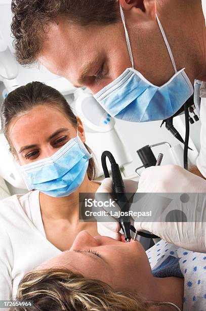 Two Dentist Professionals Working On A Patient Stock Photo - Download Image Now - Adult, Assistance, Beauty