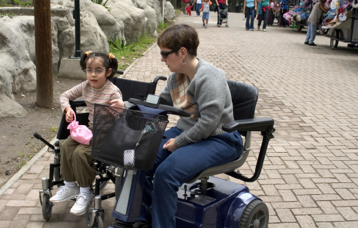 disabled mother with her daughter enjoying a ride at the park (chapultepec park in mexico city)Similar image: