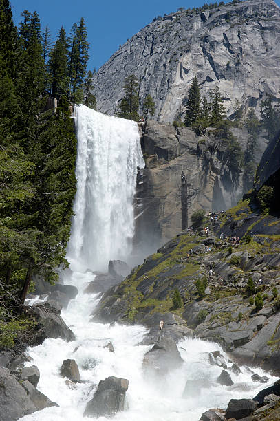 Vernal Fall in Yosemite National park Vernal falls view showing the trail on the mountain side leading to the top of the waterfall.  If you look closely you can see many people walking the misty trail to the top.  Seeing the people allows the viewer to understand the sheer size of the area in the photo. vernal utah stock pictures, royalty-free photos & images