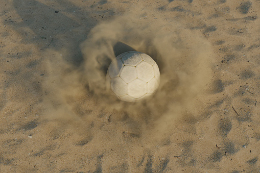 3D rendering of a rotating soccer ball on a sand surface