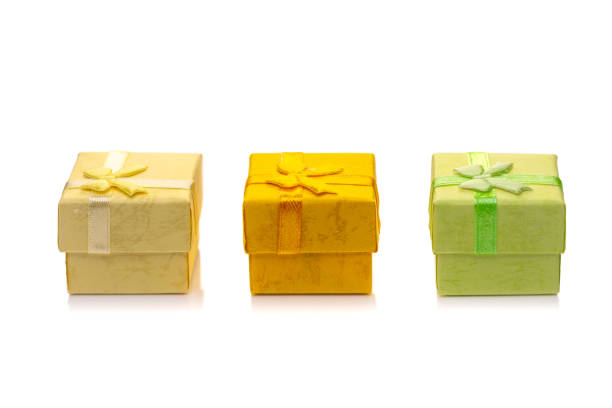 Close up shot of gift box wrapped in craft paper and decorated with green satin ribbon bow, isolated on white background.