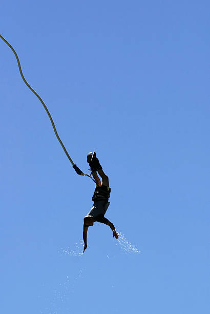 Bungee Jumper over the Kawarau River "Bungee jumper on the upswing with water coming off his hands, over the Kawarau river near Queenstown, New Zeland." bungee jumping stock pictures, royalty-free photos & images
