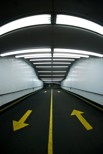 Groovy fluorescent tubes and yellow arrows lead the way down into an underground parking garage