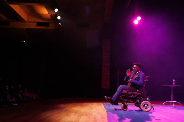 istock Man in a wheelchair giving a speech in a technology convention 1726577796