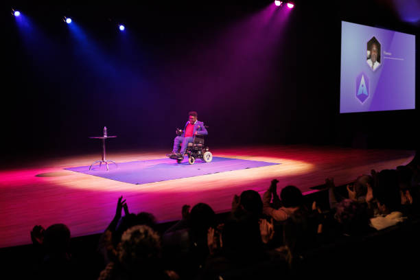 istock Man in a wheelchair giving a speech in a conference 1726578336