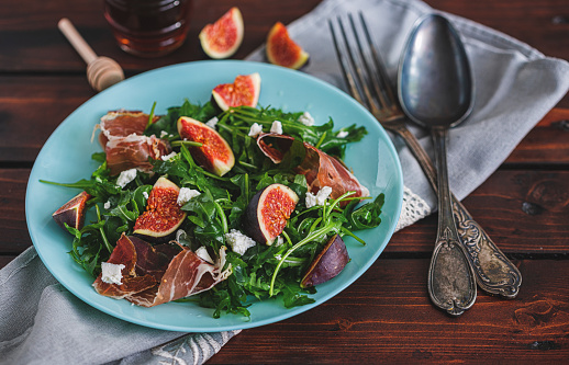 Delicious fig salad with arugula, prosciutto and goat cheese