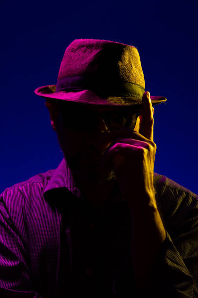 istock Mysterious serious man with a beard wearing a hat and sunglasses touching his hat. 1726595426