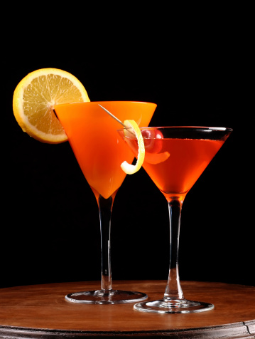 two drinks on wood table with black background. shot in studio