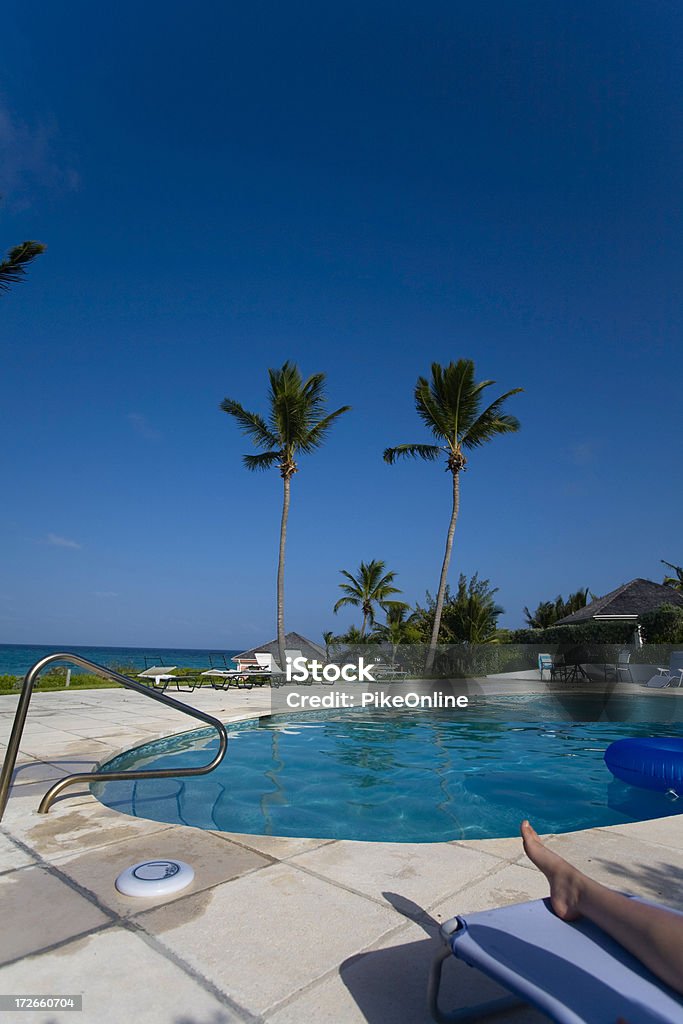 Poolside Relax Female foot visible while relaxing by the pool overlooking the ocean in the Bahamas. Bahamas Stock Photo