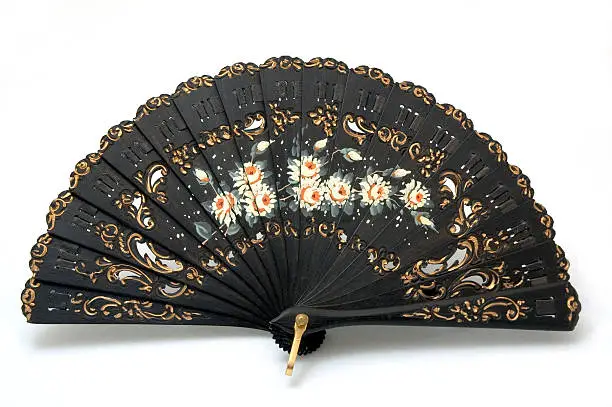 "Close-up of a beautiful hand-painted fan from Spain, made out of black ebony wood.  On a white background."