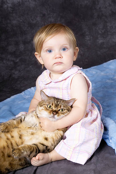 Photograph of a baby girl holding her favorite pet cat. Photographed with Sigma SD-10 digital SLR.