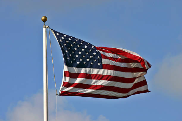 American flag on a pole with a gold orb at the top