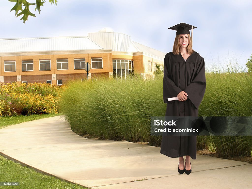 University Graduate A graduate standing outside of a university. Achievement Stock Photo