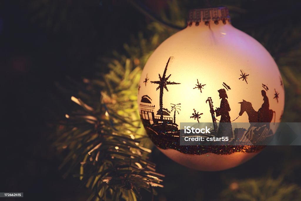 Religious: Nativity Scene silhouette on Christmas Ornament Christmas Ornament with silhouette of nativity scene with Mary, Joseph, and Bethlehem. Ornament is hanging from branch of tree. Horizontal image would be good for Chistian or religious use. Christmas Stock Photo