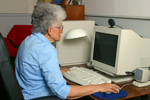 A senior citizen working on the computer.Click