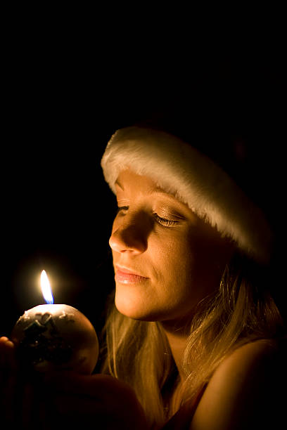 istock Woman in a santa's hat isolated on black 172662849