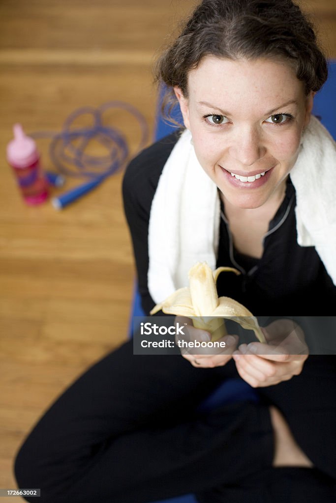 Linda jovem mulher comendo a banana depois do exercício - Foto de stock de 18-19 Anos royalty-free