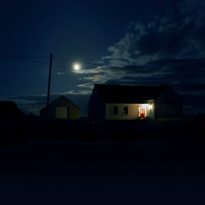 House in the night lit by the moon