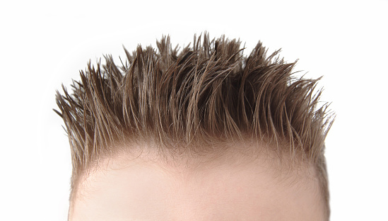 Close up of a spiky flattop hairdo on a young boy. Image photographed on a white background.