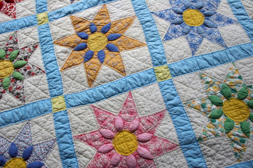 Vintage quilt spread on bed.