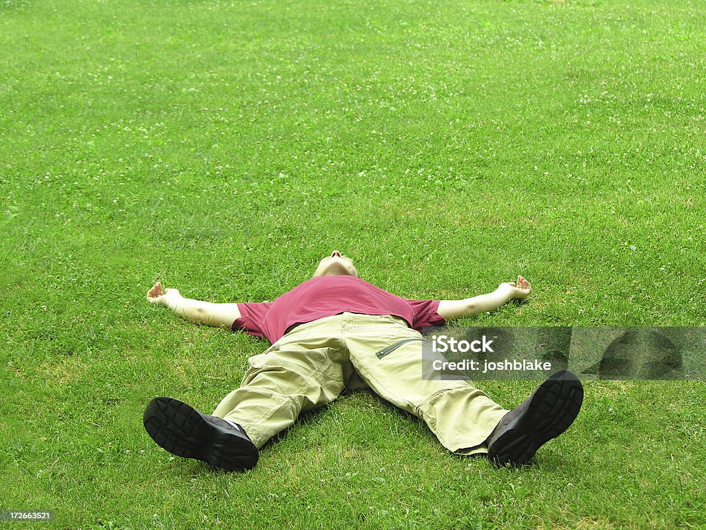 Wiped Out male lays flat in grass Men Stock Photo