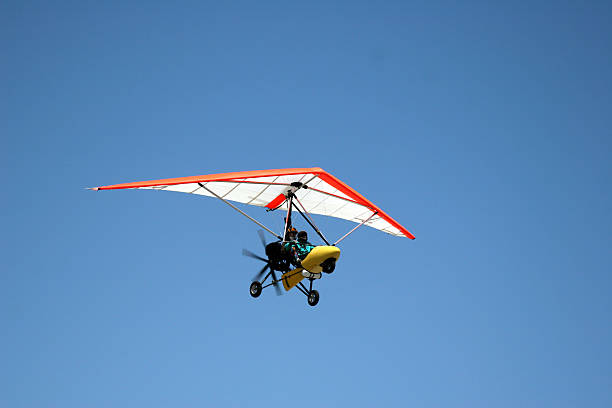 Ultralight Aircraft-1 Airborne Motorized Ultralight Glider in a cloudless blue sky. Click on an image to go to my Civilian Airplane Lightbox. ultralight photos stock pictures, royalty-free photos & images