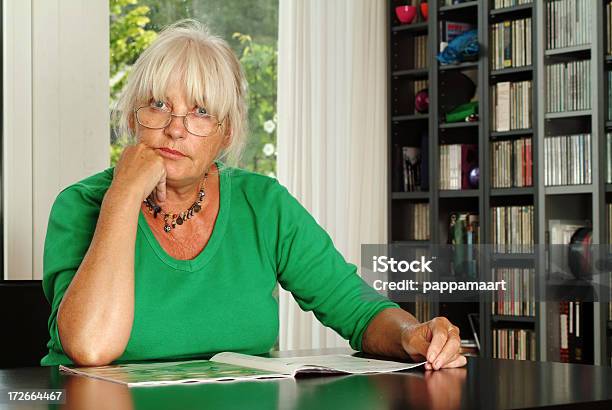 Denken Senior Frau An Einem Tisch Mit Magazine Stockfoto und mehr Bilder von Eine Frau allein - Eine Frau allein, Frauen, Tisch