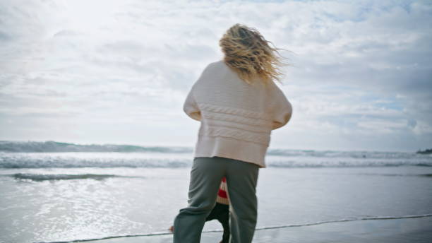 istock Laughing parent spinning kid on spring ocean beach. Joyful curly boy having fun 1726646291