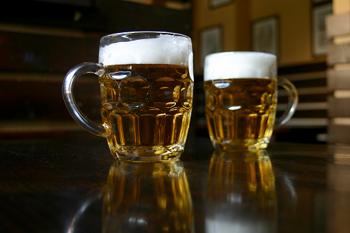 High angle view of two types of craft beer served in pint glasses placed on a bar counter