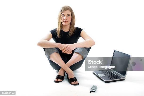 Mujer Sentada Junto A Una Computadora Portátil Foto de stock y más banco de imágenes de Mujeres - Mujeres, Vista de frente, Cabello largo