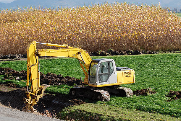 Excavator with bucket widening drainage ditch