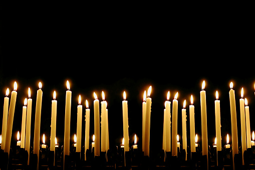 a pattern of candles in the dark of a church