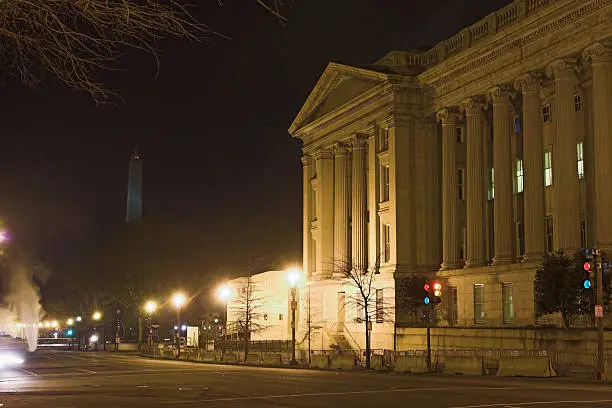 Washington D.C. by night with smoke coming from the outlets on the roads. On the right is the treasury department.