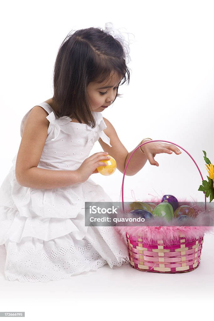 Adorabile bambina Counting uova di Pasqua nel cestello su bianco - Foto stock royalty-free di Abbigliamento elegante