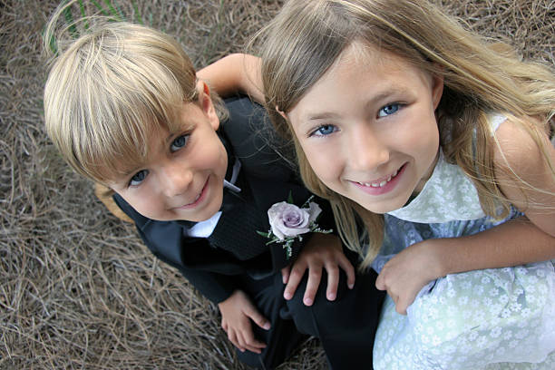 Cute Flower Girl and Ring bearer at a wedding A flower girl and Ring bearer huddle up for a photograph at a lavish wedding. ring bearer stock pictures, royalty-free photos & images