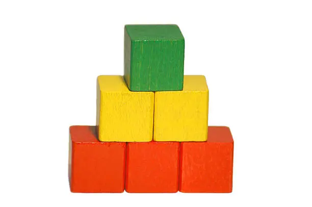 a pyramid made of wooden coloured blocks' buildings. it could be used for metaphorical scenarios.