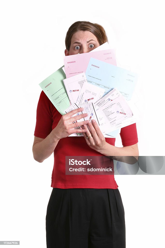 Female In Debt A woman looking very stressed holding a stack of overdue bills. Banking Stock Photo