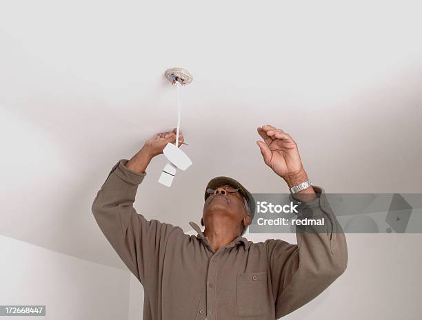 Foto de Fixação A Luz e mais fotos de stock de Eletricista - Eletricista, Interior de casa, Origem Africana