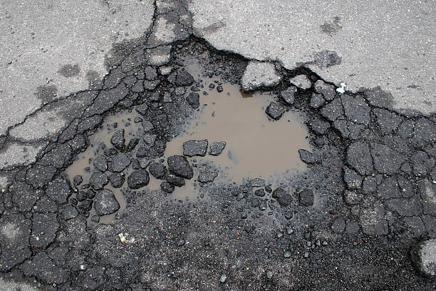Pot Hole hole in the road shot on overcast day tar stock pictures, royalty-free photos & images