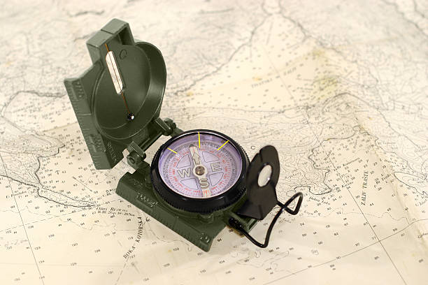 boussole sur la carte - folded compass coordination pursuit photos et images de collection