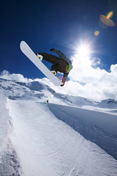 A snowboarder mid air performing a trick jump stock photo