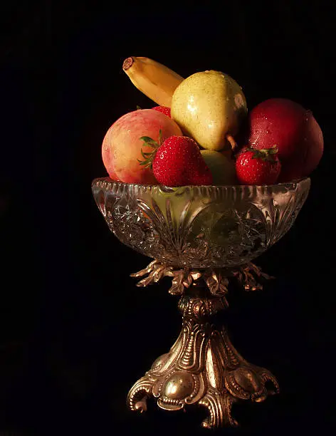 A variety of fruit displayed in a Victorian-style glass bowl.