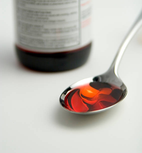 prendre un médicament - cough medicine spoon medicine tablespoon photos et images de collection