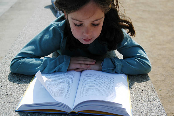 istock Young girl reading a book 172670686