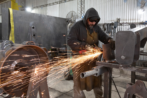 men working and welding in metallurgical workshop