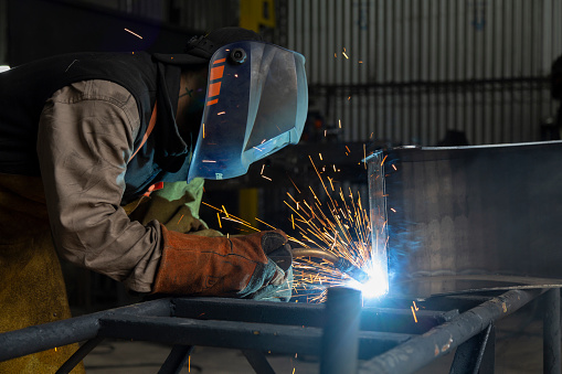men working and welding in metallurgical workshop