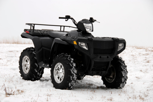 A black atv in a winter setting.