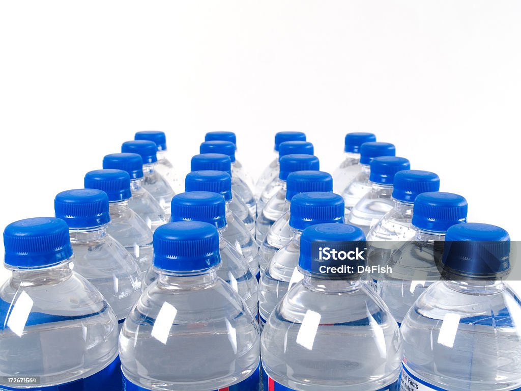 Case of filled water bottles with blue caps A Case Of Water Bottles Isolated On White Background. Copy Space. Water Bottle Stock Photo